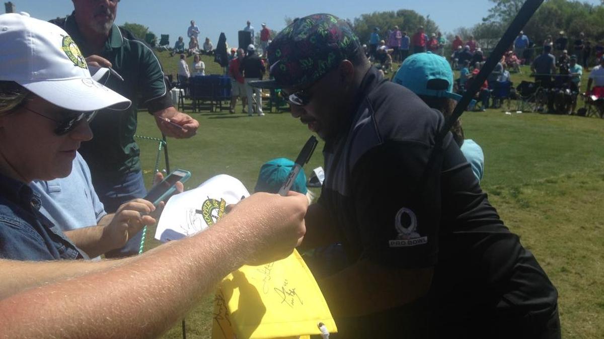 Carolina Panthers fullback Mike Tolbert pens his autograph on various items for fans during Monday After the Masters at The Dye Club at Barefoot Resort.