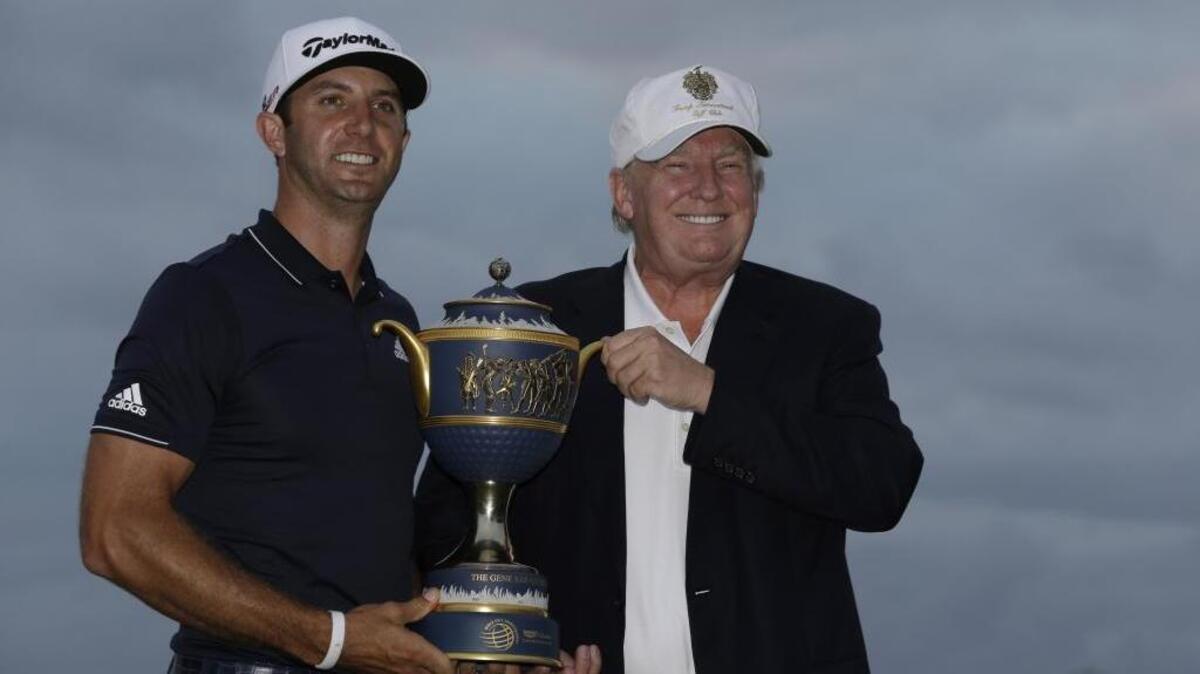 Dustin Johnson holds the Gene Sarazen Cup with course owner Donald Trump after winning the Cadillac Championship at Trump Doral Resort in Miami in March 2015. The two played a round of golf with Tiger Woods and Brad Faxon on Friday at Trump National in Jupiter, Fla.