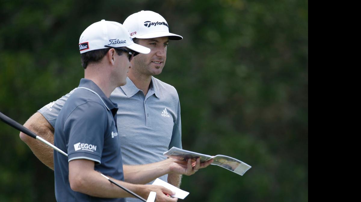 
Zach Johnson (left) and Dustin Johnson talk while waiting their turn on the second tee during the first round of The Players Championship.
