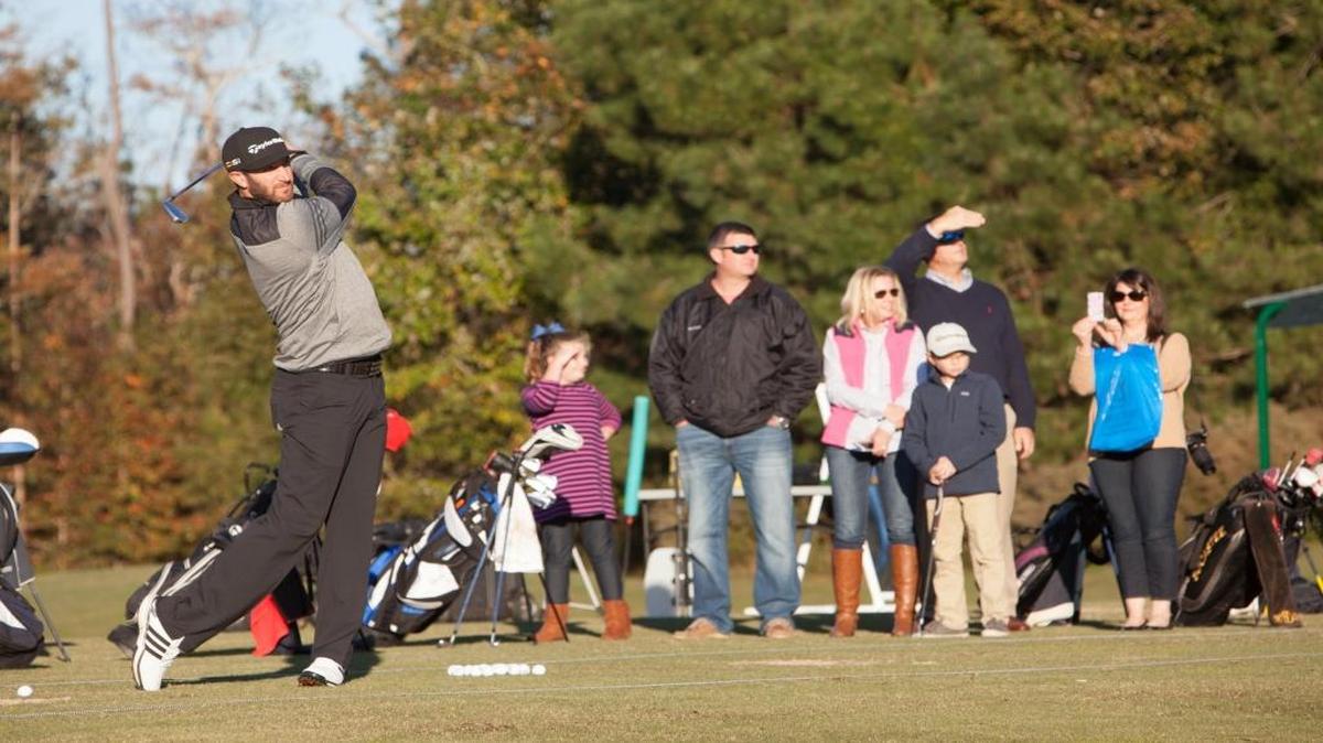 Dustin Johnson (left) hits balls on his golf school’s driving range at TPC Myrtle Beach in November.