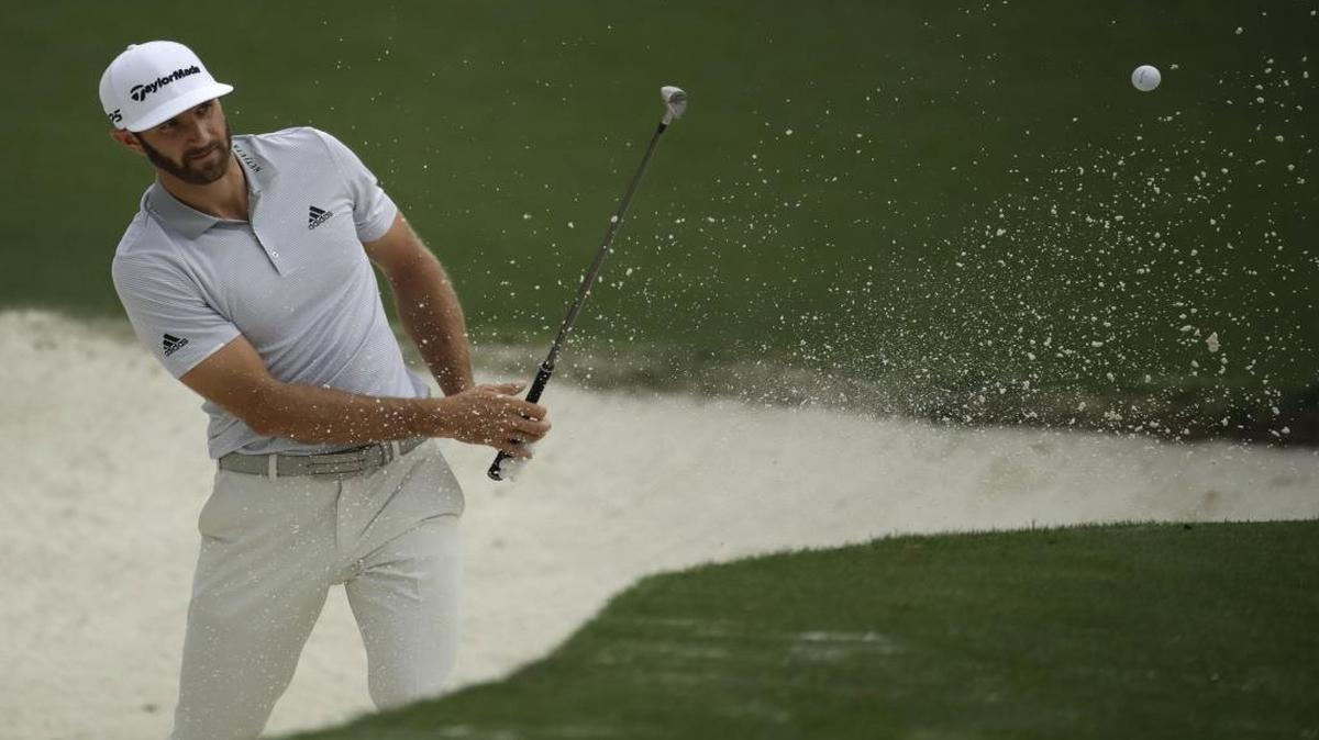 Dustin Johnson hits from a bunker on the 10th hole during a practice round for the Masters Tournament on Wednesday morning, prior to his spill down a staircase at his rental home that has his participation in the tournament in doubt.