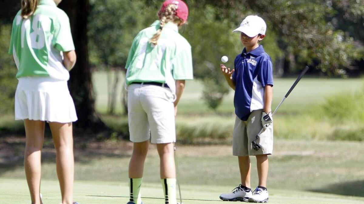 
Campbell McClain (right) of the River Oaks Bears waits for his turn to putt in a PGA Junior League Golf match against the Wachesaw Warriors at Wachesaw Plantation Club in July.
