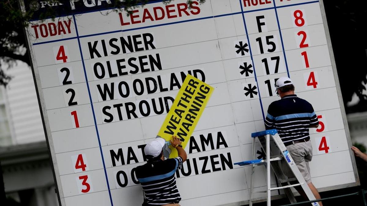 A course worker puts up a weather warning sign as play was suspended during the second round of the PGA Championship.