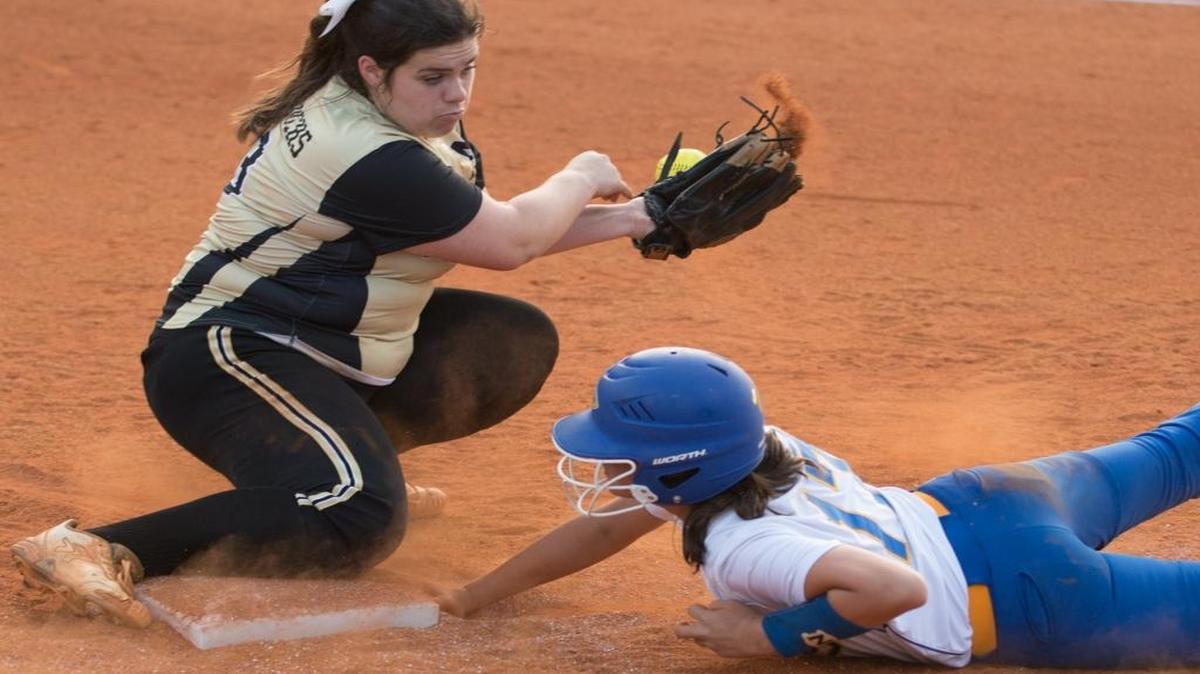North Myrtle Beach’s Emmalee Ballard dives back to the base as Manning’s Laura Beth Thigpen bobbles the throw.