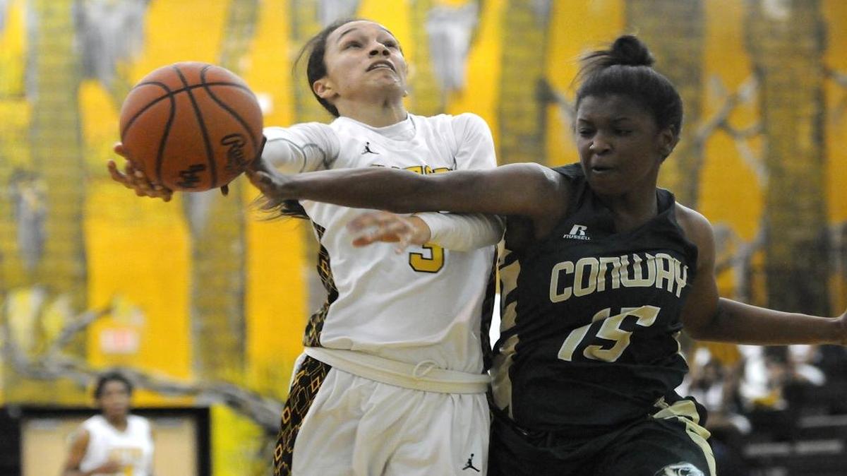 Conway’s Zakera Chadmon swipes at the ball as a Goose Creek player makes a shot attempt on Friday night.
