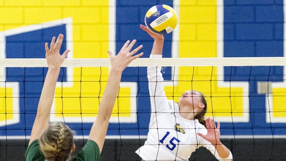 North Myrtle Beach’s Maddie Roy tips the ball over a Myrtle Beach defender during Tuesday’s match. The Seahawks won the match in five sets.