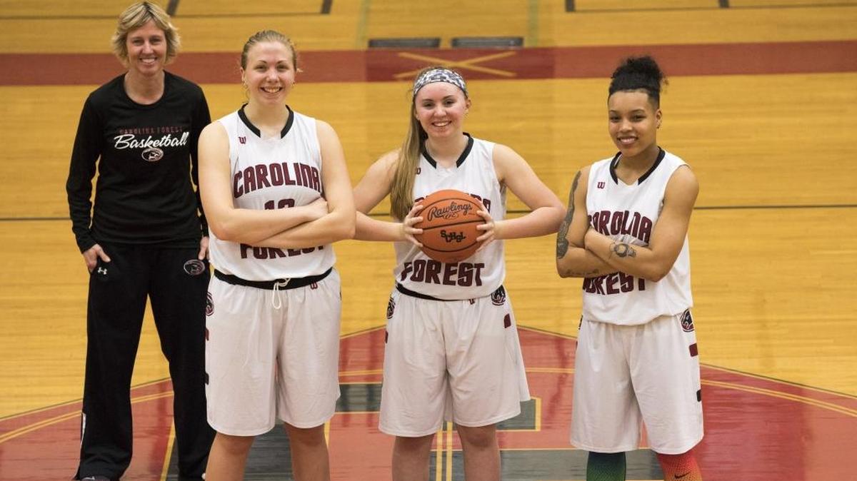 Carolina Forest girls basketball coach Stacy Hughes stands with team members (L-R) Ellen Nardella, Alexis Tomlin and Cheyenne Pyles-Moultrie.