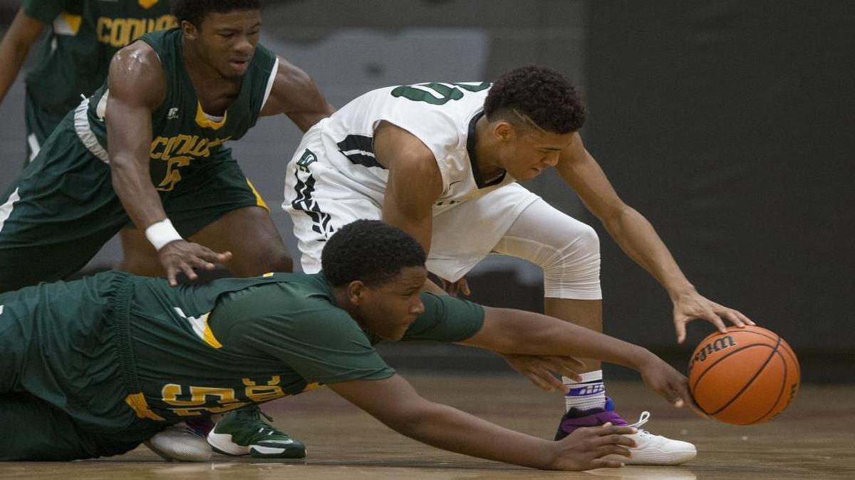 Conway’s Tonka Hemingway (52) and Juwan Moody (5) go for a steal against Durham Academy’s Jordon Davis (10) during Thursday’s Panther Classic final.