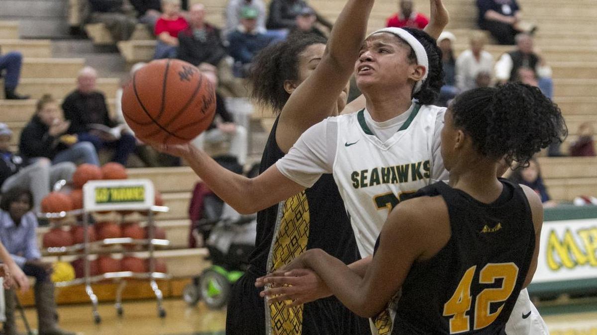Myrtle Beach’s Gabby Moore (center) gets off shot under between Goose Creek defenders Friday.