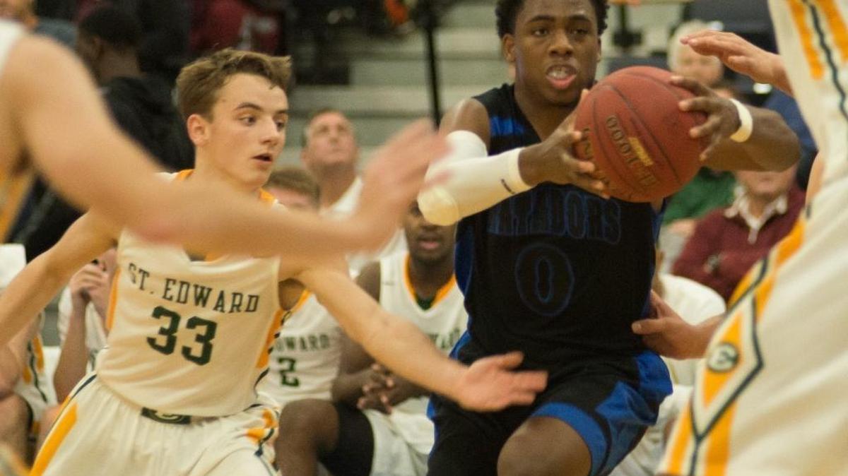 Shadow Mountain’s JJ Rhymes (center) drives as St Edward’s Sean Flannery (33) defends Monday.