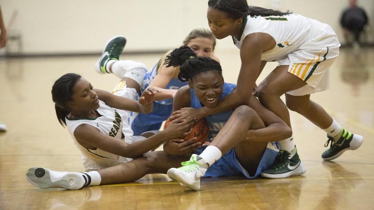 St. James’ Kaswana Hayes (center) tries to hold on as Myrtle Beach defenders try to wrestle the ball away.