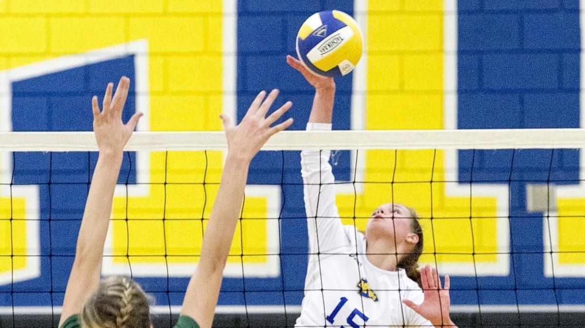 North Myrtle Beach's Maddie Roy tips the ball past the outstretched arms of Myrtle Beach player during a match between the rival programs last year.