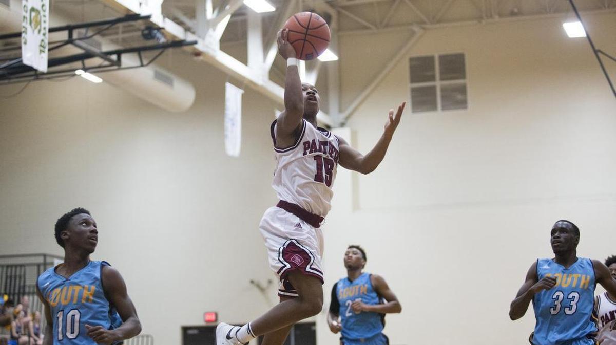 Carolina Forest’s Richmond Collier (center) puts up a shot over South Florence’s Giovanni Rivers on Friday night.