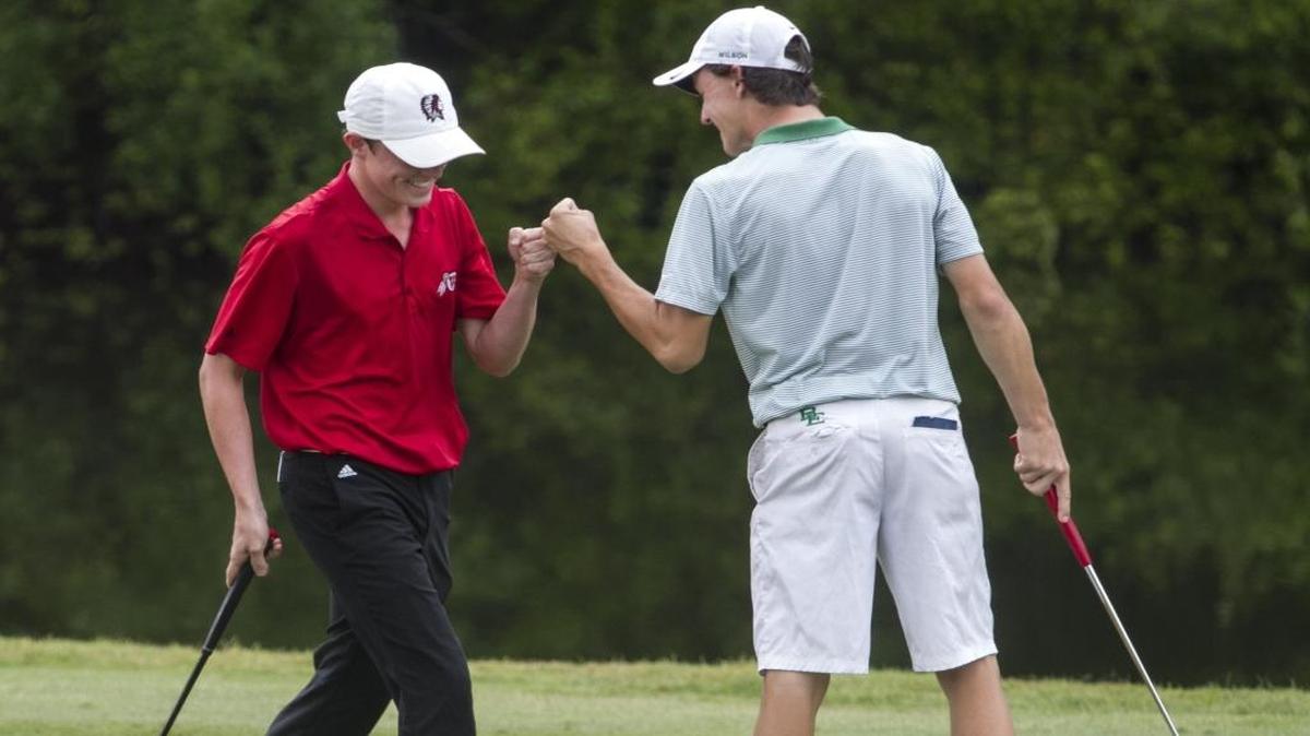 Patrick Golden of Waccamaw High School gets a fist bump from Bishop England’s Jamie Wilson during last season’s Class 2A golf championship at True Blue Golf Course in Pawleys Island. The Warriors and Battling Bishops are the top two teams in Class 3A, according to the latest S.C. High School Golf Association poll.