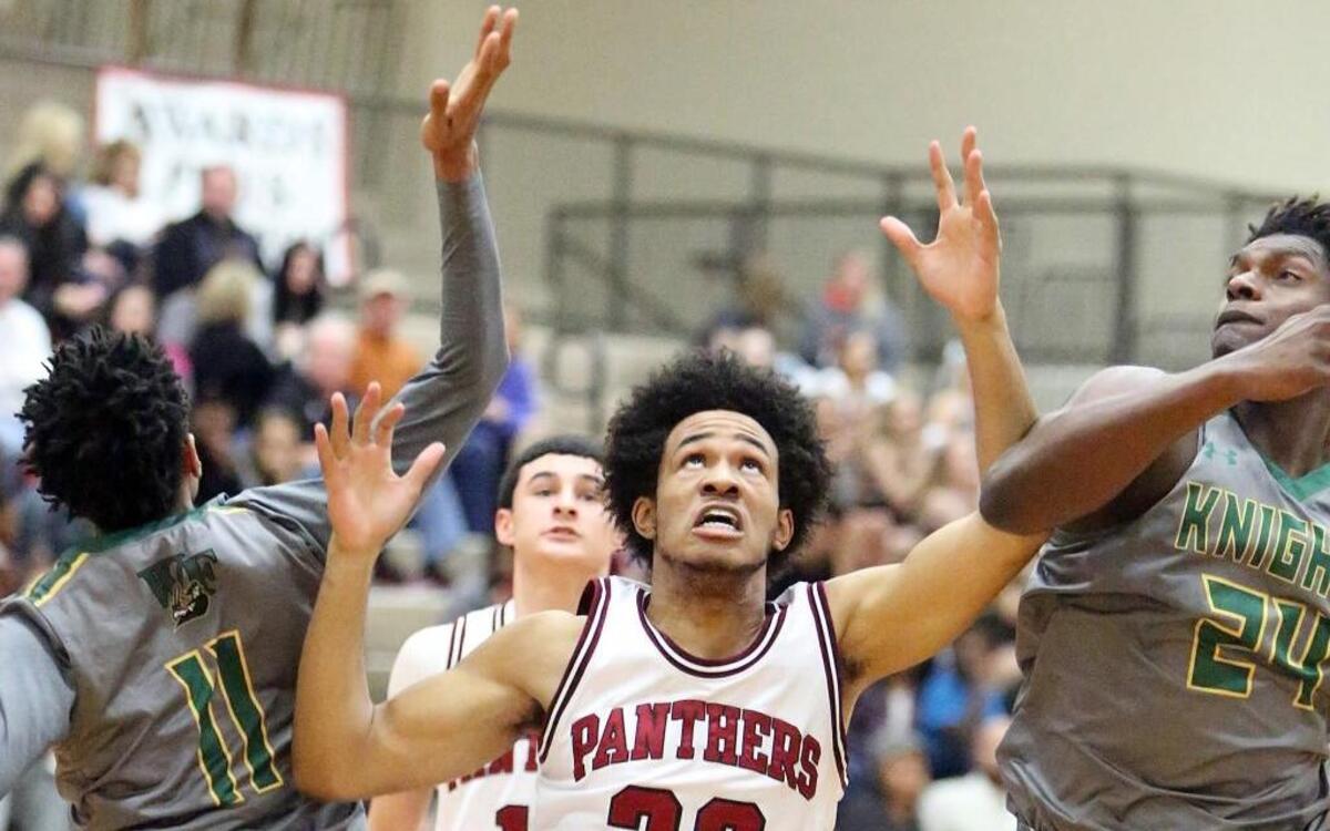 Carolina Forest’s Tariq Timmons (center) looks to grab a rebound while surrounded by West Florence defenders.