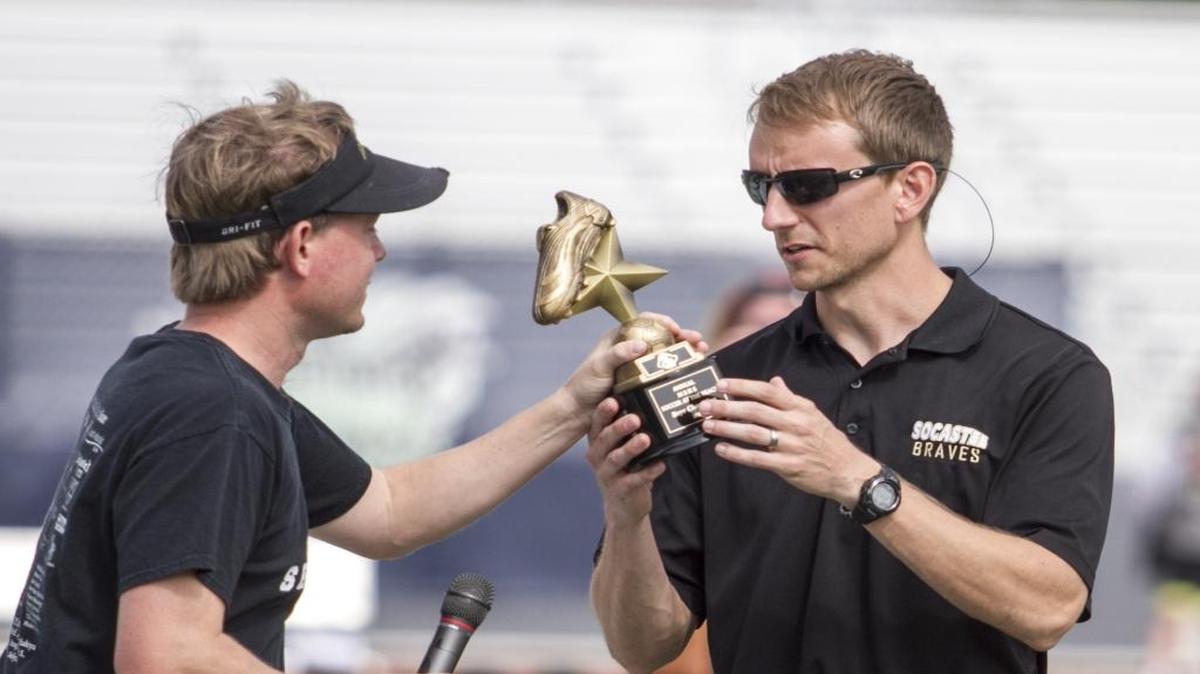 Myrtle Beach coach Jason Himmelsbach passes the Soccer at the Beach championship trophy to Socastee’s coach Byron Owen earlier this season.