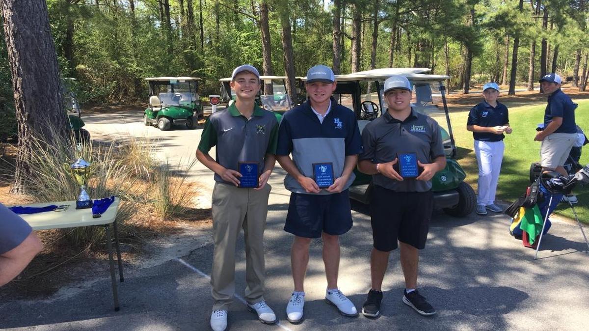 From left to right, Blue Jacket Invitational medalist Holden Grigg of Myrtle Beach accepts his award with Hilton Head Island’s Travis Mancill and North Myrtle Beach’s McClure Thompson following the final round of play at Diamondback Golf Course in Loris.