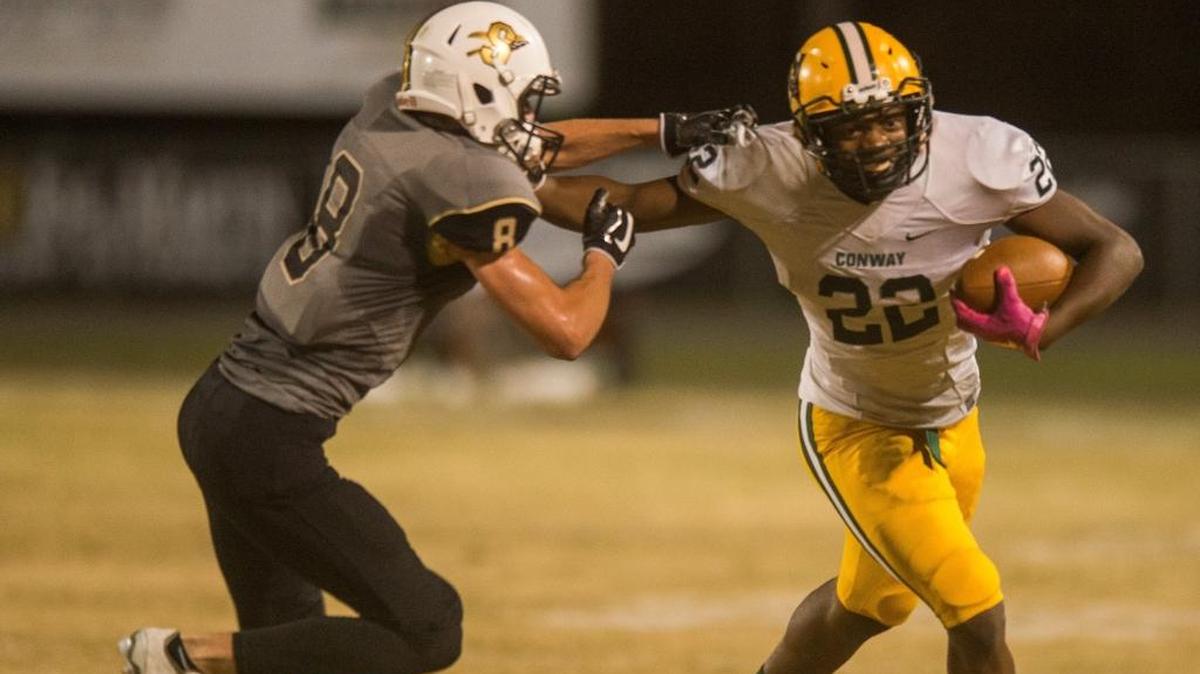 Conway running back Antonio Long tries to create separation between him and a Socastee tackler last Friday night.