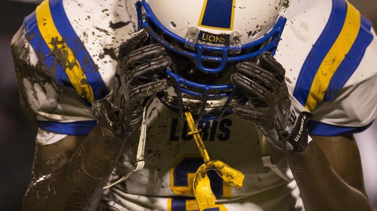 Loris cornerback Bobby Gore pulls mud and grass from his helmet after a fumbled punt return Friday.