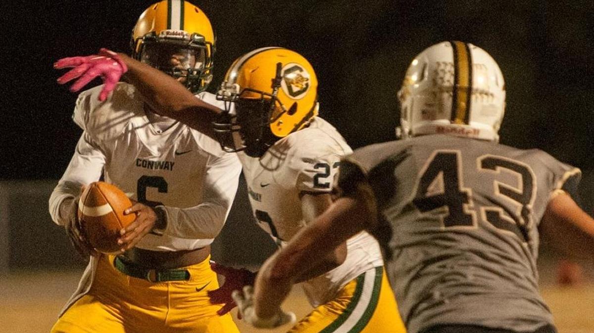 Conway quarterback D’Wuan Grainger fakes the handoff while looking downfield during Friday’s game at Socastee.
