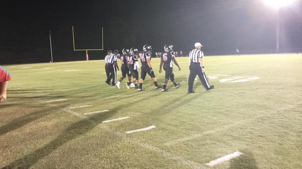 Representing Waccamaw, seniors Kelton Grant (2), Elliott Reid (24), Ethan Chastain (74) and Jabbrel Drayton (6) walk with the officials to the coin toss before Friday's win over Marion