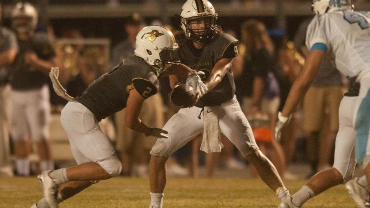 Socastee quarterback Hunter Illing keeps an eye on a St. James tackler as he puts the ball in the waiting arms of running back Nick Carnucci on Friday night.