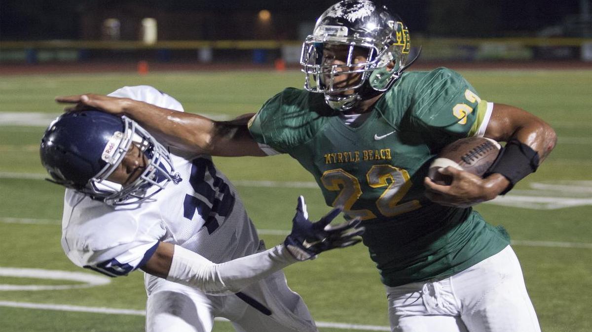 Myrtle Beach running back Brandon Sinclair (22) stiff-arms Georgetown’s Cavonte Gamble during the first quarter Friday night.