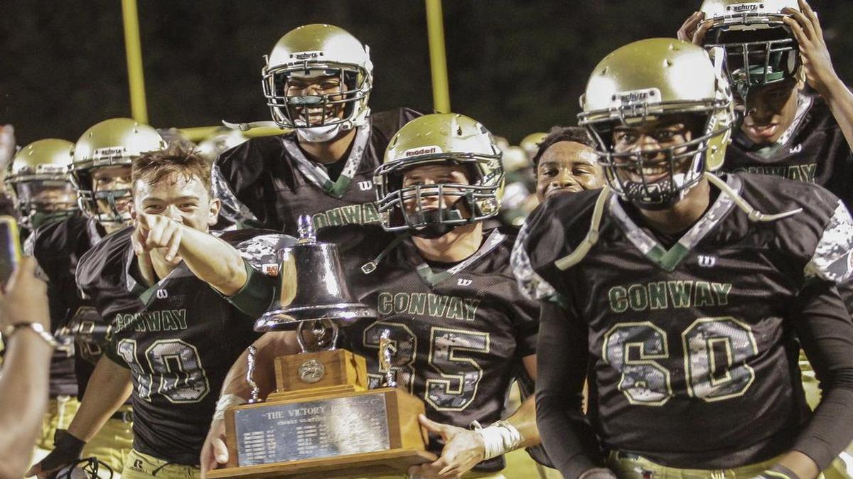 
Conway players hold up the Victory Bell trophy after beating Myrtle Beach earlier this year.
