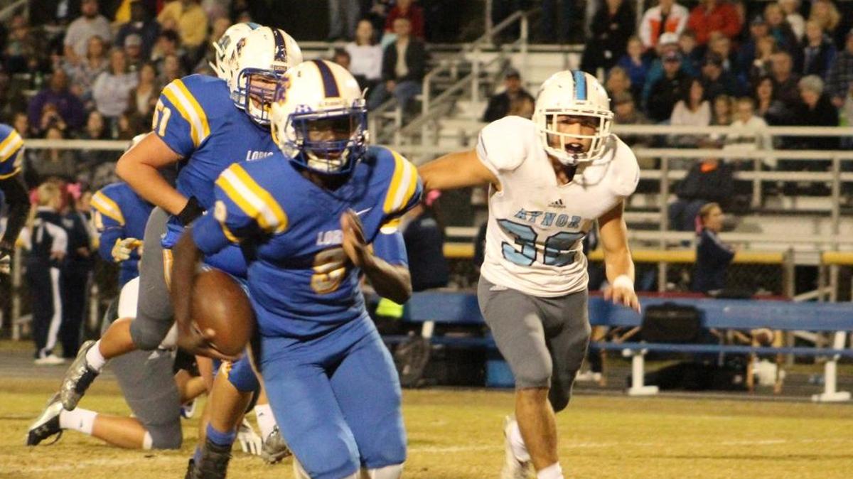 Loris quarterback Levon Stevenson (9) scrambles away from the Aynor defense, including linebacker Blade Rabon (30) during the Lions' 49-27 victory on Friday.