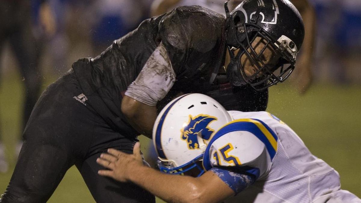 Carolina Forest running back Jaylen Johnson (18) tries to break a tackle by Loris defender Timmy Bell (15) during gridiron action last season.