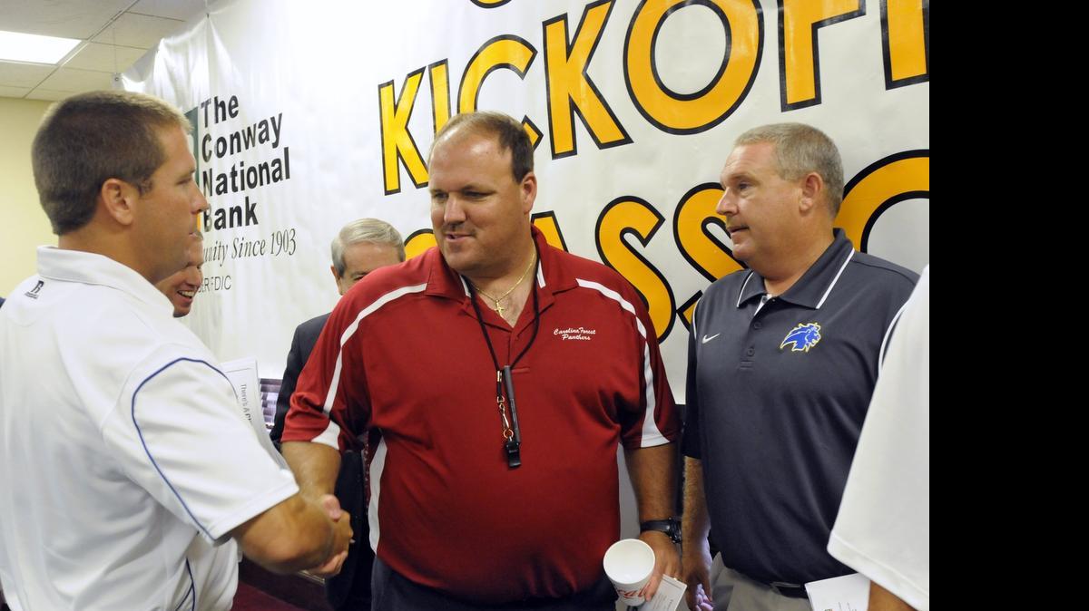 
Carolina Forest coach Marc Morris (center) shakes hands with North Myrtle Beach coach Blair Hardin (left) as Loris coach Jamie Snider (right) looks during last year’s CNB Kickoff Classic luncheon.
