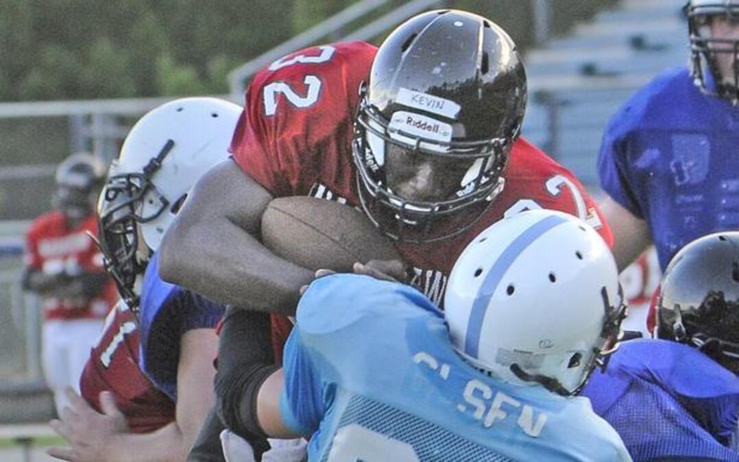 
Waccamaw running back Kevin Gasque muscles over the St. James defensive line to score during a scrimmage Tuesday.
