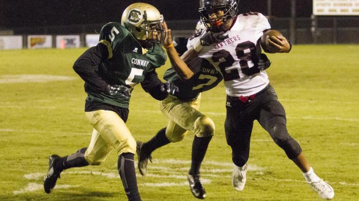 Carolina Forest’s Dyverse Simmons looks to elude Conway defenders Friday.