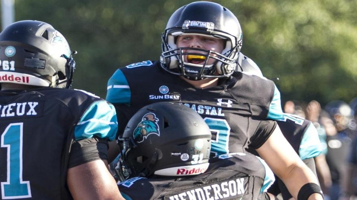 Coastal Carolina quarterback Tyler Keane celebrates with running back De’Angelo Henderson during the Chanticleers’ 41-21 rout of Furman on Saturday.
