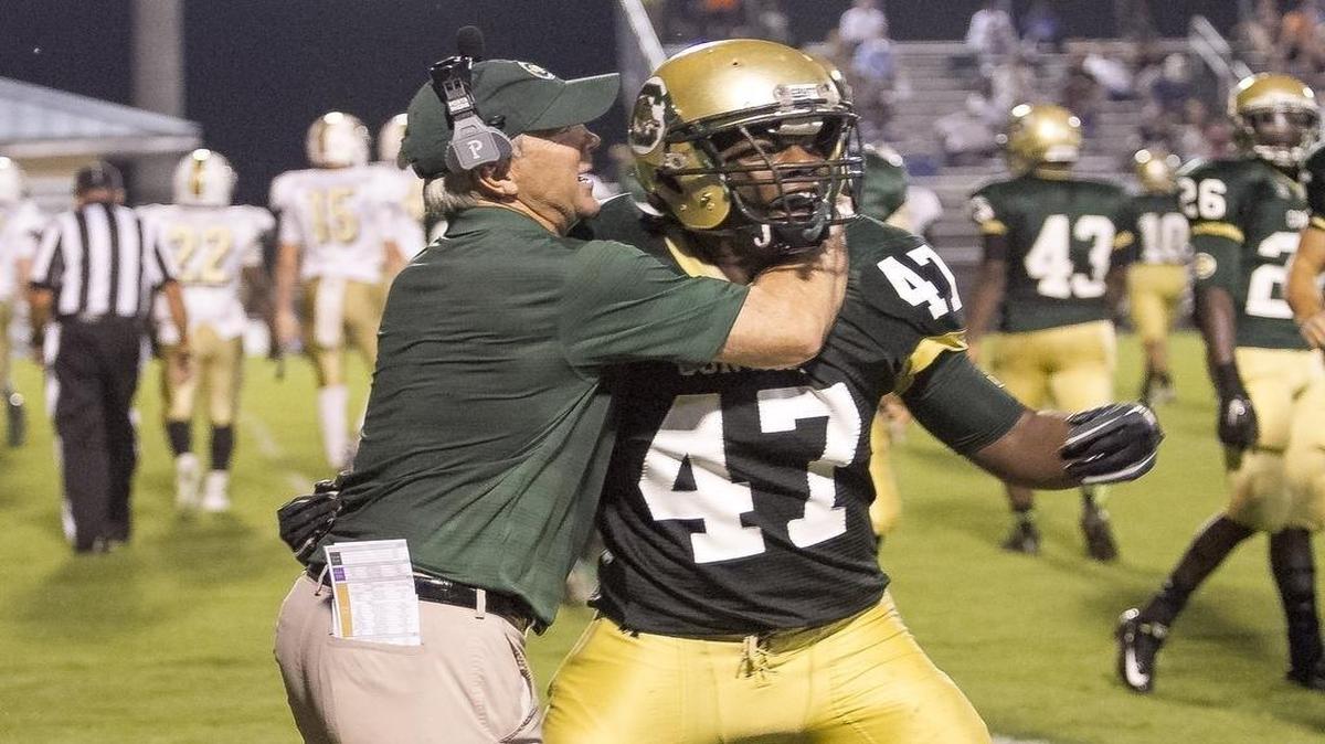 Conway’s Zuri Phifer gets a congratulatory hug from head coach Chuck Jordan after making a big tackle last year.