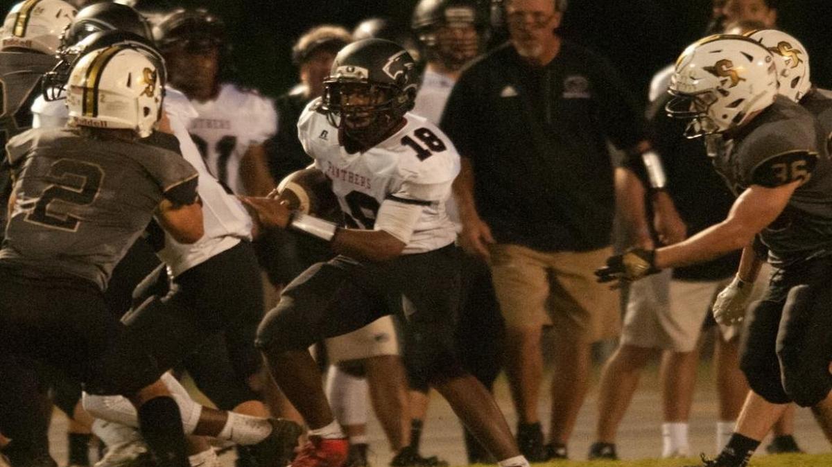 Carolina Forest’s Jaylen Johnson (18) looks to elude Socastee defenders Friday night.