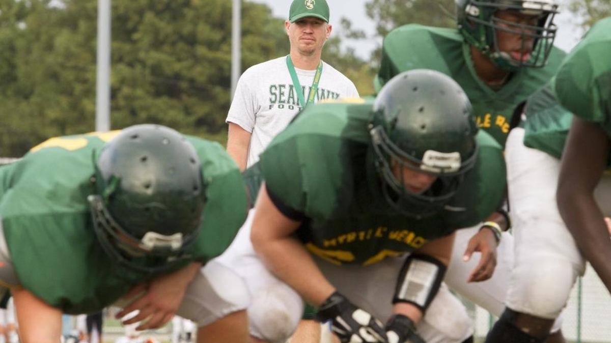 Myrtle Beach football coach Mickey Wilson looks on as players prepare for special teams work during practice.