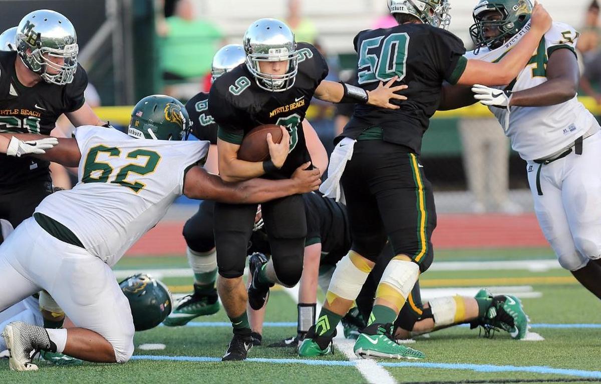 Myrtle Beach quarterback Luke Doty is corraled by a West Florence defensive lineman during Friday’s game at Doug Shaw Memorial Stadium.