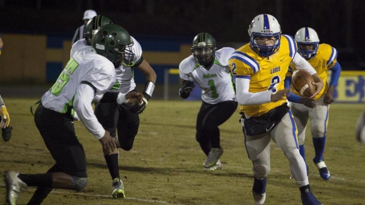 Loris quarterback Ta’Jay Williams (2) looks for an opening in the Lake Marion defense.