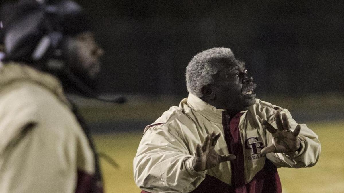 Carvers Bay coach Nate Thompson gives instructions to players during a game last season from his spot on the sideline.