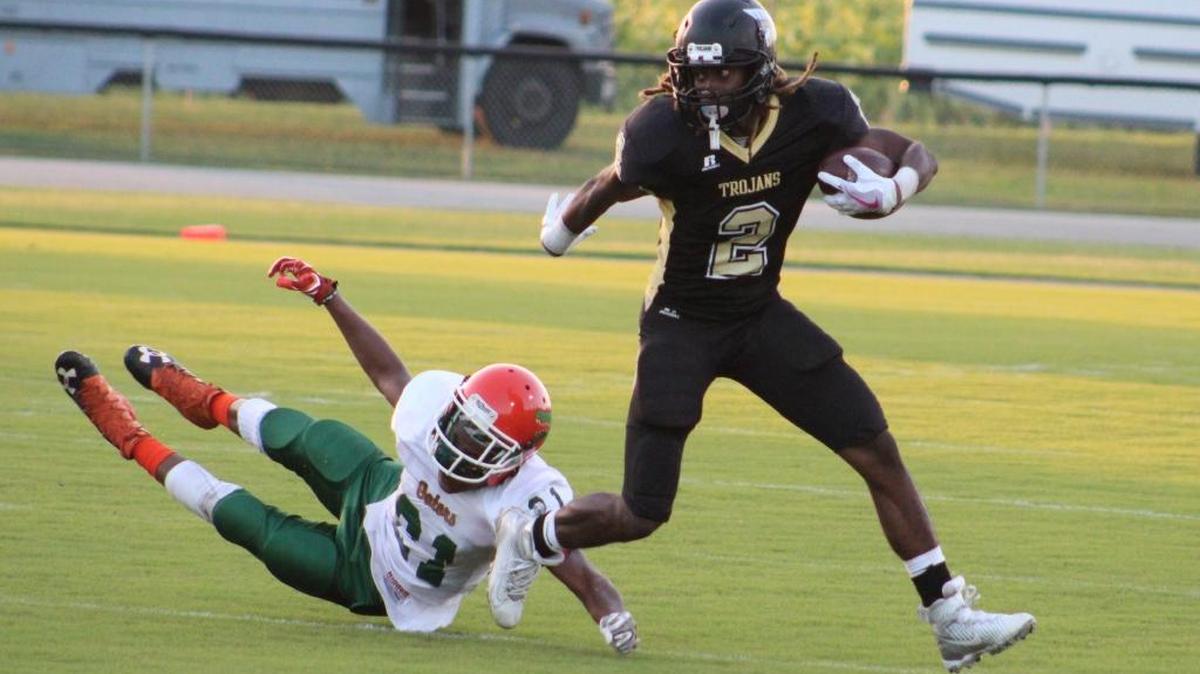 Green Sea Floyds running back Anwain Graham (2) fends off a tackle attempt by East Columbus defender Armani Gayden (21) during the Trojans' 31-0 victory on Friday.