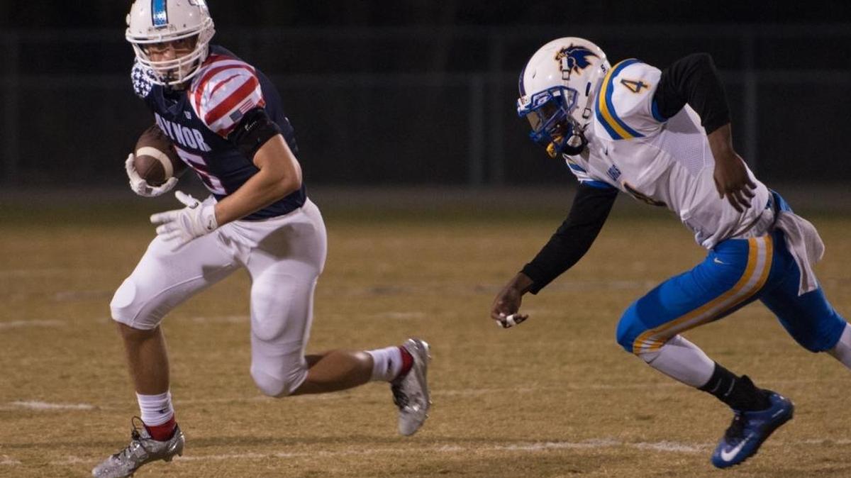 Aynor’s Caleb Jenerette (right) looks to elude a Loris defenders earlier this season.