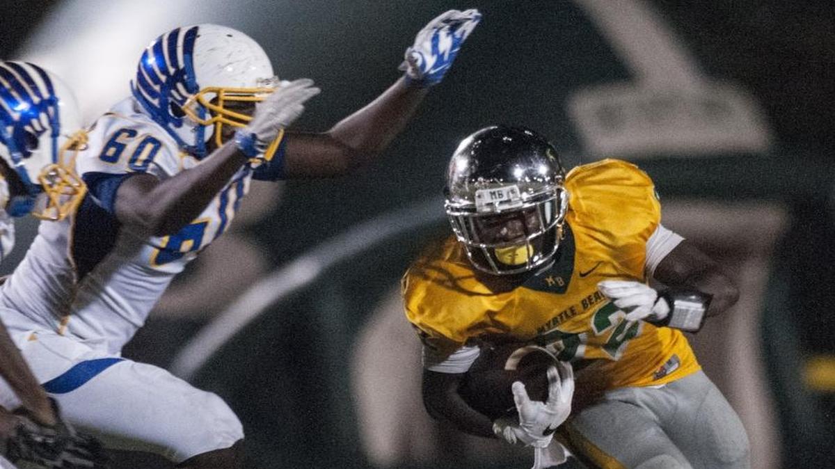 Myrtle Beach running back Jermani Green surges past North Myrtle Beach defenders during their game earlier this season.