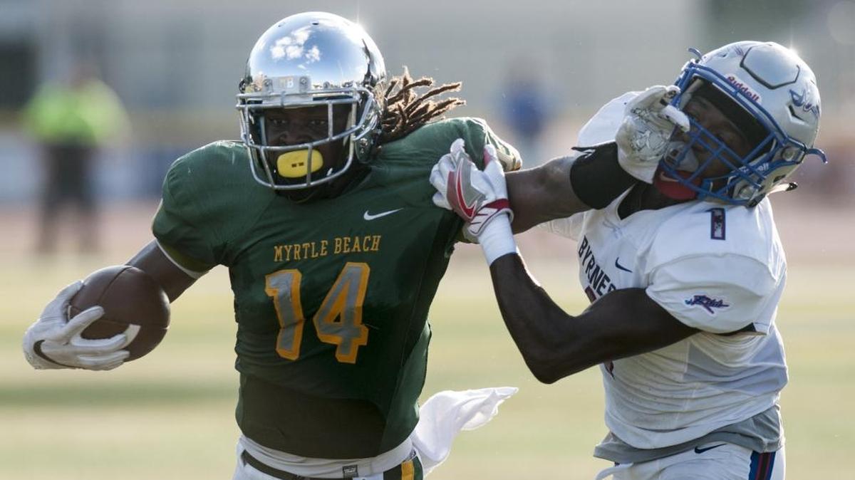 Myrtle Beach’s Keyonte Sessions stiff-arms Byrnes’ Aaron Watson en route to a score in the first quarter Saturday.