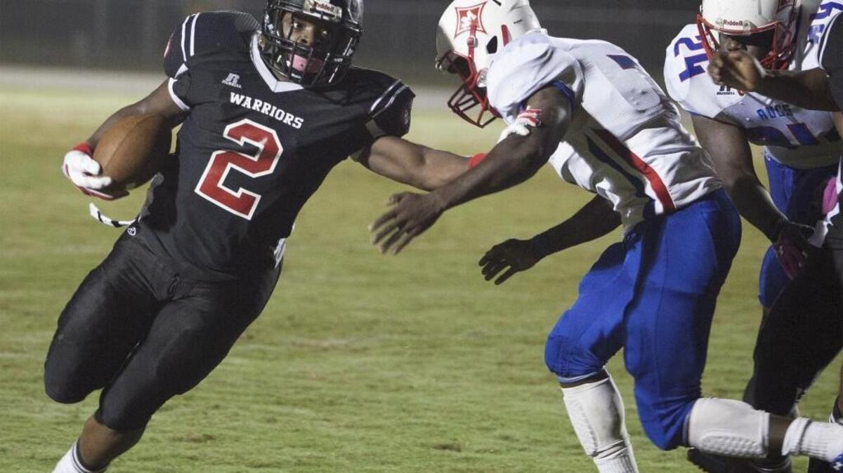 Waccamaw’s Kelton Grant (2) stiff-arms Mullins’ Tyrei Platt during the first quarter Friday.