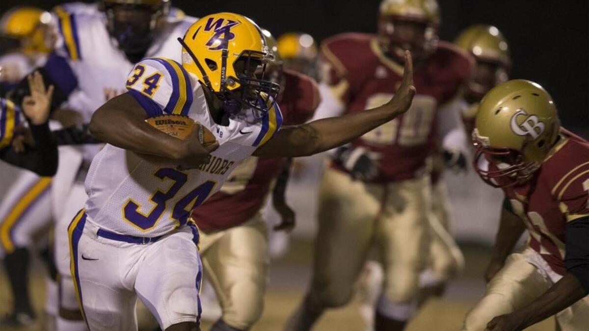 Whale Branch running back Irvin Mulligan (34) tries to stiff arm a Carvers Bay defender during the second round of Class 2A playoffs Friday night at Carvers Bay High School.