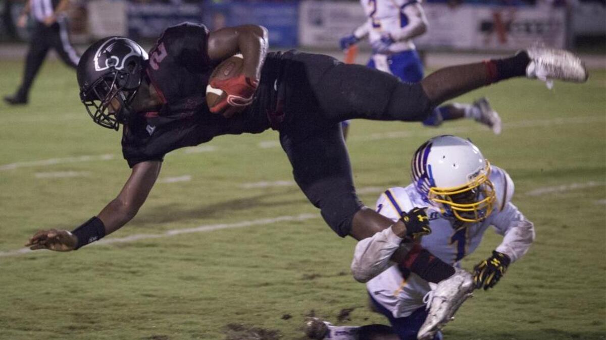 
Carolina Forest wide receiver Xavier Lynch (24) is tripped up by North Myrtle Beach’s Mike Gore on Friday.
