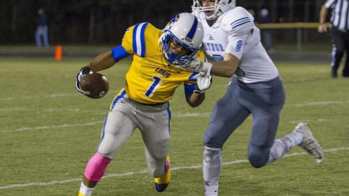 Loris’ Desmond Dozier (left) is brought down by Aynor’s Blake Gore during Friday’s game.