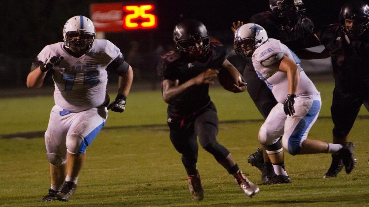 
Carolina Forest’s Dyverse Simmons (center) looks for yardage against St. James on Friday.
