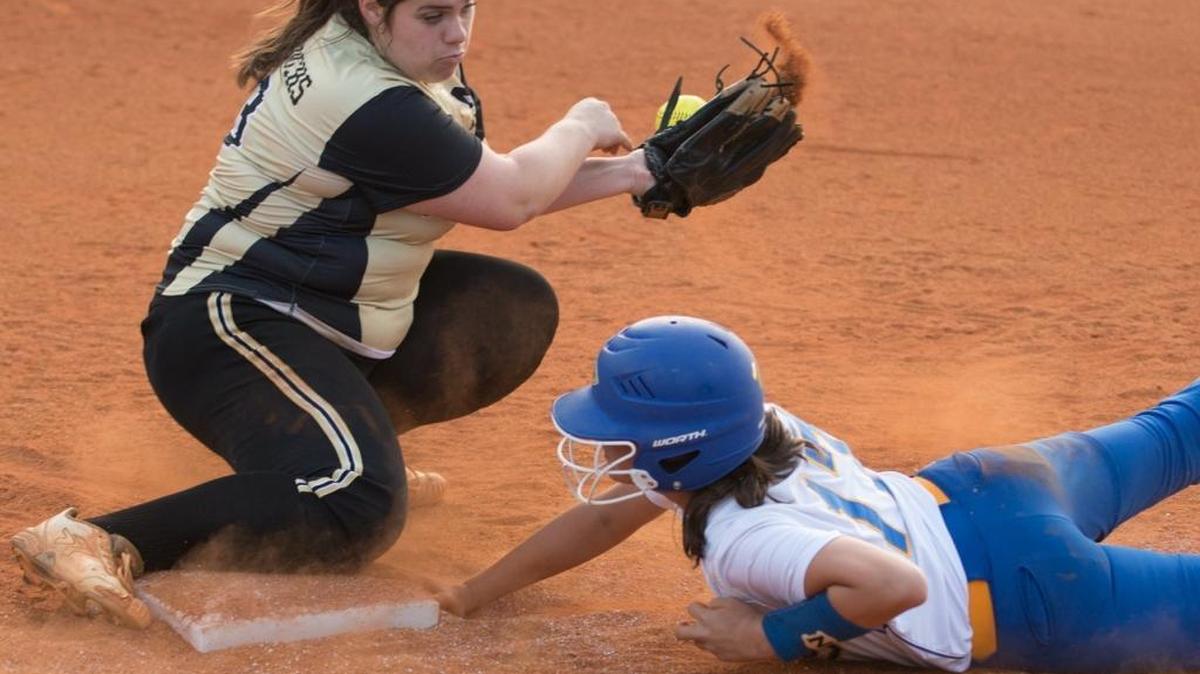 North Myrtle Beach’s Emmalee Ballard dives back to the base as Manning’s Laura Beth Thigpen bobbles the catch in last week’s game. The Chiefs were informed before the game that their legendary coach James Graves would retire at season’s end.